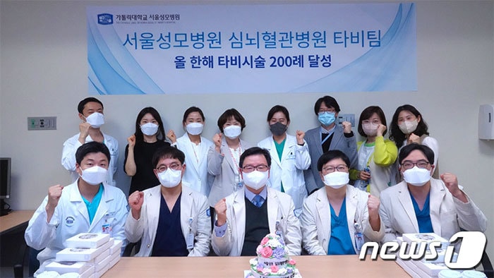 28일 오후 4시 서울성모병원 윤승규 병원장과 장기육 심뇌혈관병원장, 타비팀과 관계자들이 타비시술 연간 200례 달성을 기념하는 사진을 찍었다.(서울성모병원 제공.)