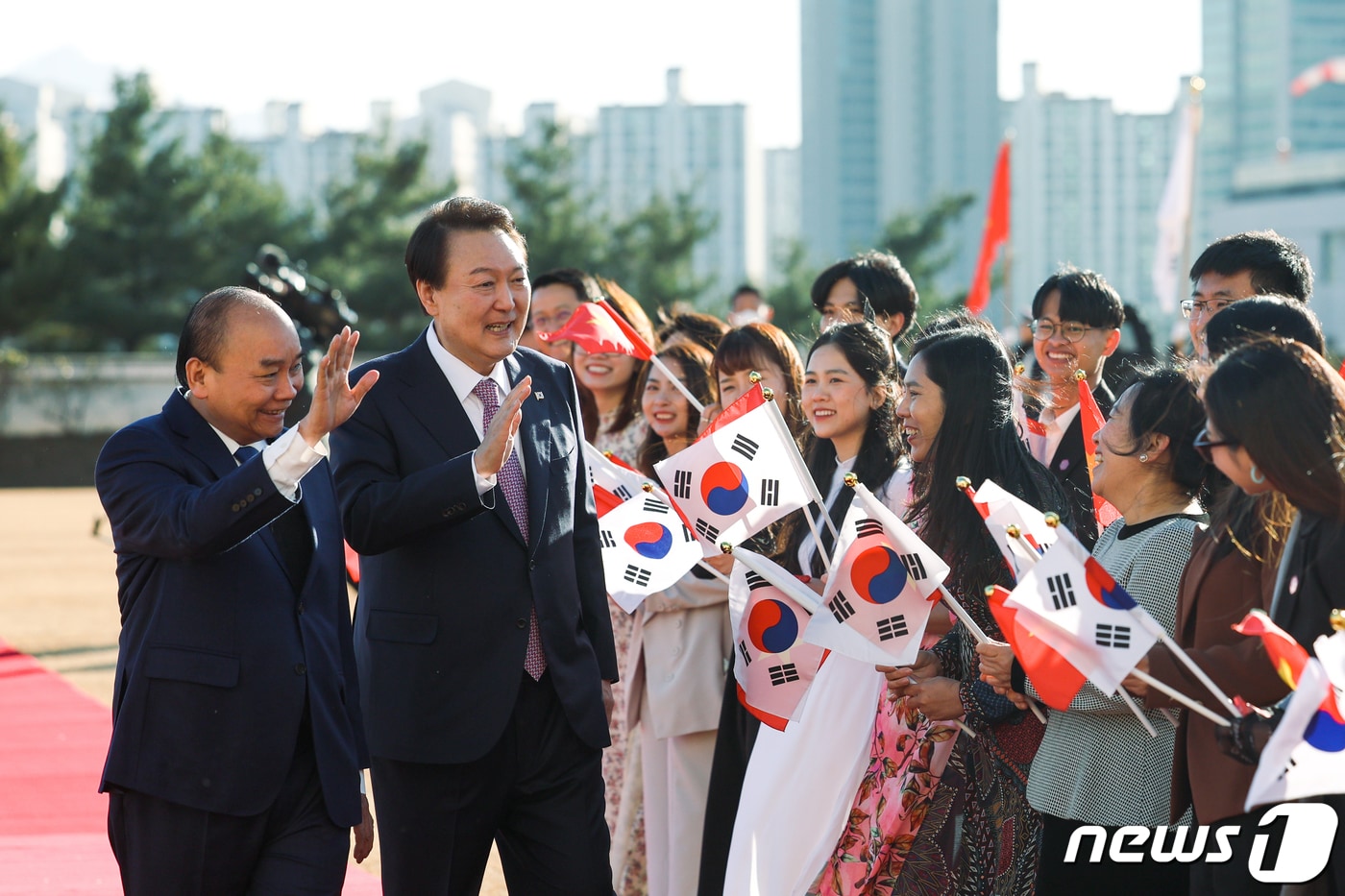 윤석열 대통령과 응우옌 쑤언 푹 베트남 국가주석이 5일 오후 용산 대통령실 청사에서 열린 공식환영식에서 양국 국기를 든 환영 인사들에게 인사하고 있다. (대통령실 제공) 2022.12.5/뉴스1 ⓒ News1 오대일 기자