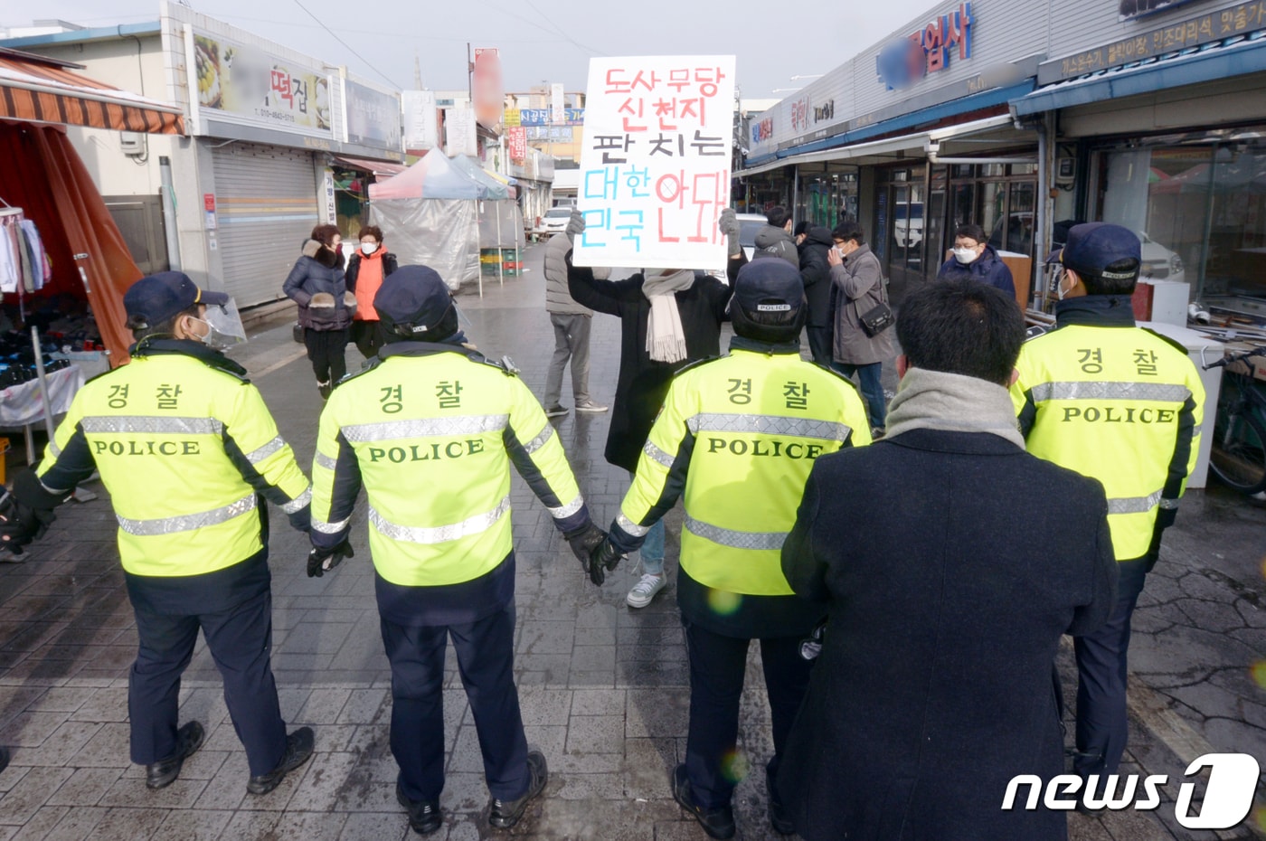 윤석열 국민의힘 대선 후보 방문을 앞둔 2022년 2월 16일 오전 광주 광산구 송정매일시장에서 광주전남대학생진보연합 관계자들이 '신천지 의혹'을 거론하며 윤 후보의 광주 방문을 반대하는 내용의 피켓을 들고 있다. 2022.2.16/뉴스1 ⓒ News1 정다움 기자
