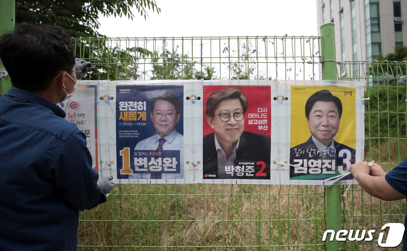 제8회 전국동시지방선거 공식 선거운동 첫날인 지난 19일 부산시 수영구 망미1동 행정복지센터 부근에서 수영구 직원들이 선거벽보를 부착하고 있는 모습. 2022.5.19/뉴스1 ⓒ News1 DB