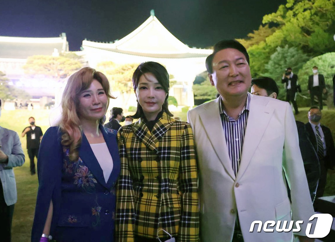윤석열 대통령과 부인 김건희 여사가 2022년 5월 22일 오후 서울 종로구 청와대 본관 대정원에서 열린 청와대 개방 특집 KBS 열린음악회에 참석해 출연진과 기념촬영하고 있다. 이때 김 여사는 크리스찬 디올의 노란색 재킷을 입었다. (대통령실 제공) 2022.5.23/뉴스1
