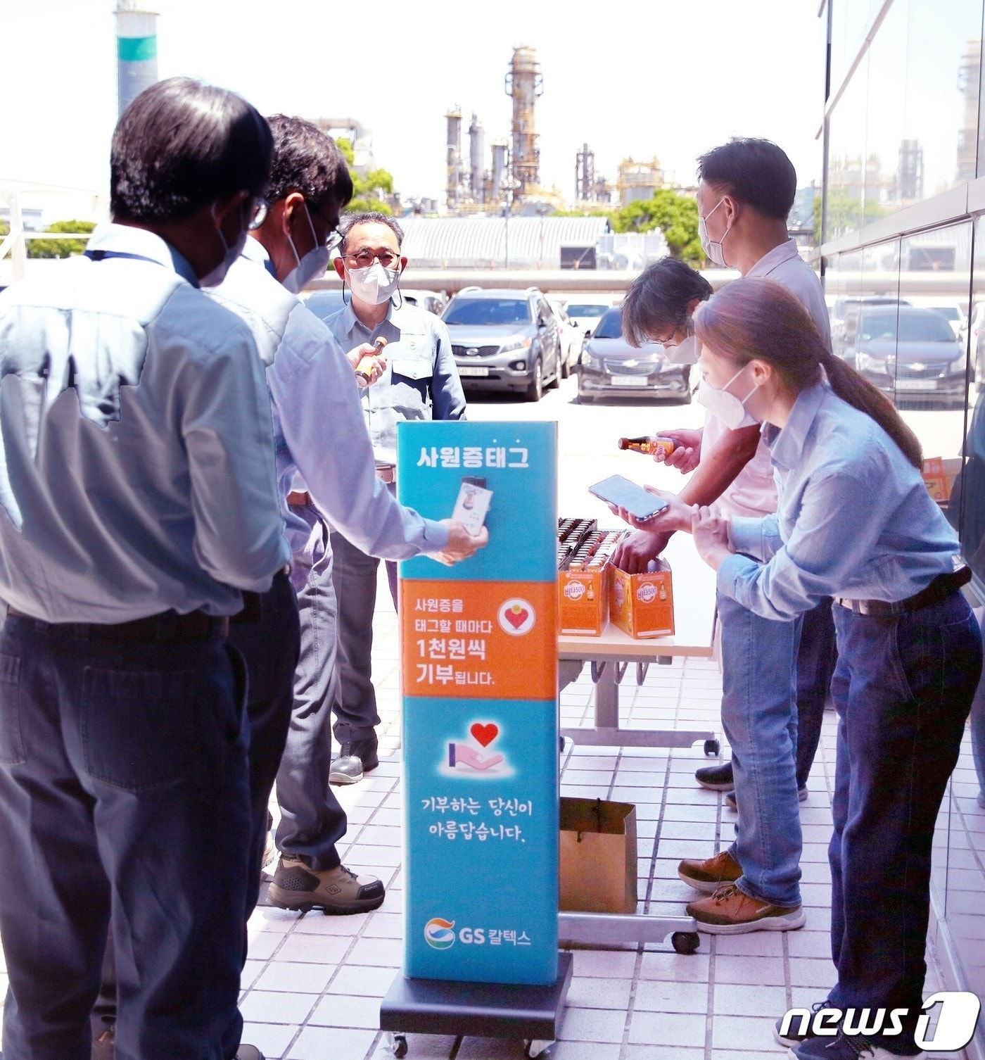 이두희 GS칼텍스 생산본부장을 비롯한 여수공장 임직원들이 27일 구내식당 출구에 비치된 '소액기부 시스템'에 사원증을 태그하며 기부에 동참하고 있다.(GS칼텍스 제공)2022.5.27/뉴스1