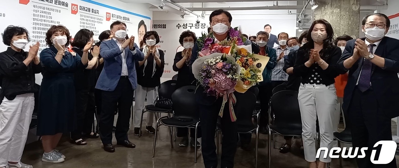 김대권 대구 수성구청장 국민의힘 후보가 2일 당선이 확실시되자 지지자로부터 꽃다발을 받고 기념촬영을 하고 있다. (김대권 후보 측 제공) 2022.6.2ⓒ 뉴스1