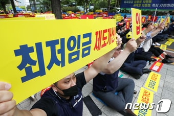 소상공인연합회(소공연) 관계자들이 서울 영등포구 여의도 국회 앞 도로에서 열린 '최저임금제도 개선 촉구 집회'에서 구호를 외치고 있다. ⓒ News1 민경석 기자