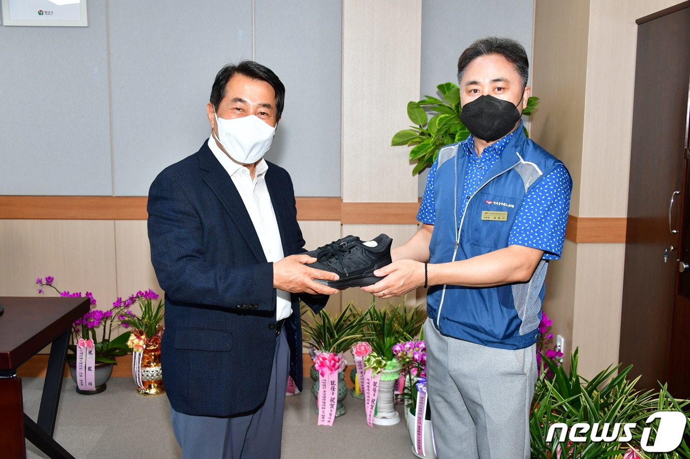 정욱서 양산시청공무원노조위원장(오른쪽)이 나동연 양산시장에게 운동화를 전달하고 있다. (양산시 제공) ⓒ 뉴스1