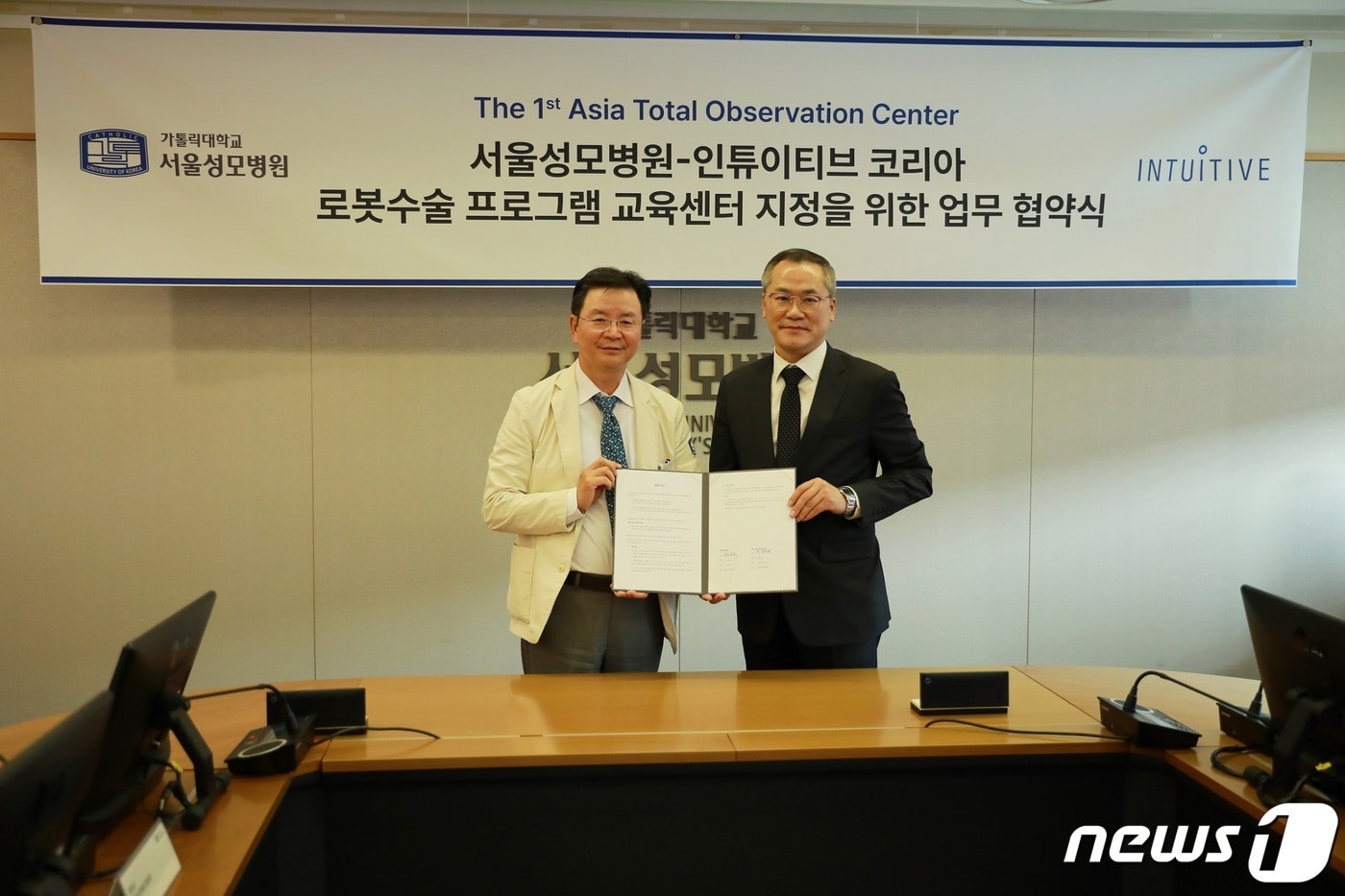윤승규 서울성모병원 병원장과 인튜이티브 최용범 한국지사대표가 아시아 최초로 '로봇수술 프로그램 교육센터(Total Observation Center)' 지정을 위한 업무협약을 체결한 후 기념사진을 촬영했다. (서울성모병원 제공)