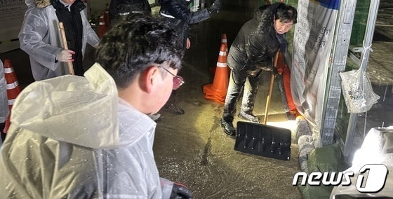 최문순 화천군수를 비롯한 군청직원들이 13일 새벽 화천산천어축제장 주변에서 빗물제거 작업을 펼치고 있다.&#40;화천군 제공&#41; 2023.1.13/뉴스1