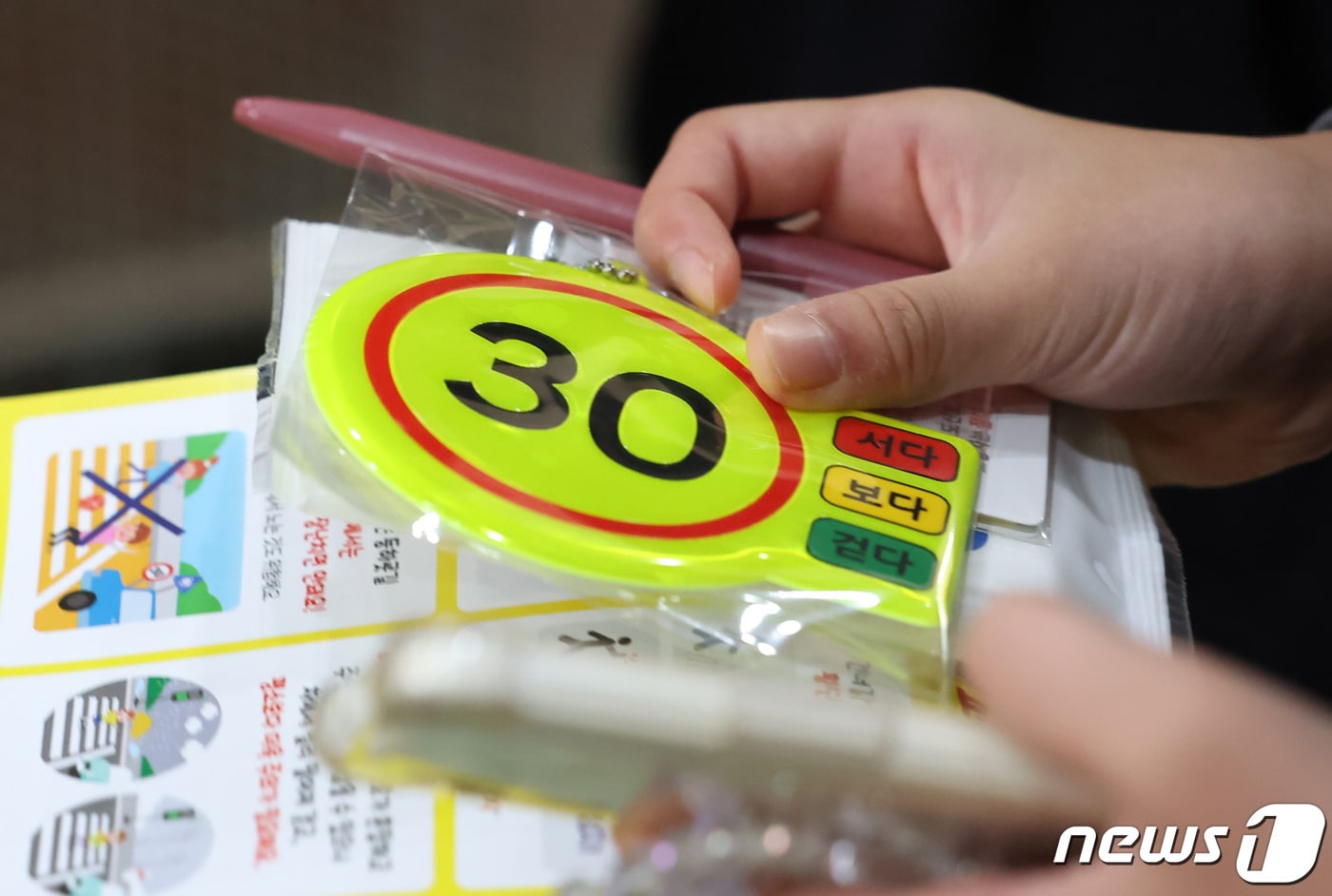 '어린이보호구역 시속 30km 이하 운행'을 나타내는 가방고리. ⓒ 뉴스1