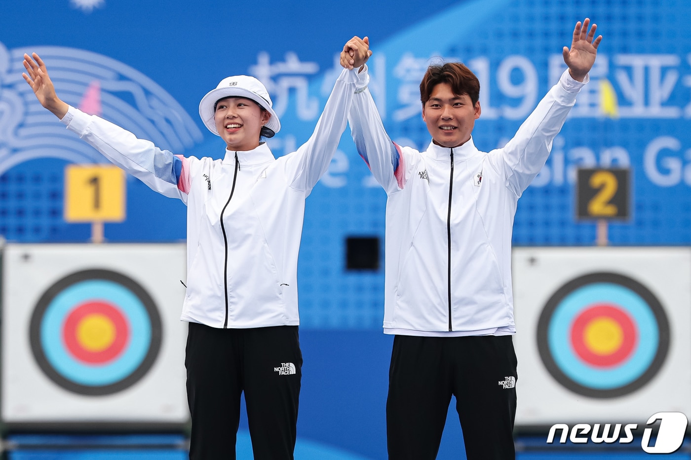 이우석과 임시현이 4일 중국 항저우 푸양 인후 스포츠센터 양궁장에서 열린 2022 항저우 아시안게임 양궁 리커브 혼성전 시상식에서 시상대에 오르며 인사하고 있다. 이우석과 임시현은 이날 결승에서 일본의 노다 사츠키-후루카와 다카하루에게 6-0 완승을 거두고 금메달을 차지했다. 2023.10.4/뉴스1 ⓒ News1 유승관 기자