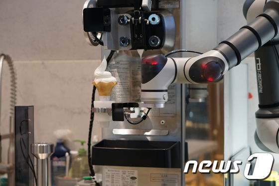 차량 관리 플랫폼 카닥과 GS칼텍스가 함께 운영하는 경기도 고양시 카닥일산주유소 내 카페 '온더로드'에 아이스크림 서빙 협동로봇이 설치됐다. 이 협동로봇은 부품조립공정 등 제조업에 활용되던 레인보우로보틱스사의 협동로봇을 기반으로 만들어졌다. (카닥 제공) 2019.12.07/뉴스1