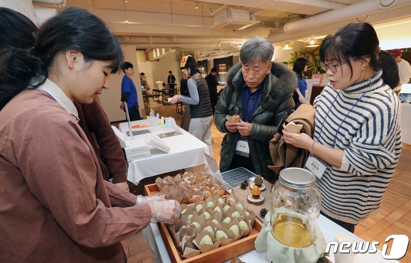서울 용산구 이태원 케이브하우스에서 열린 넥스트로컬 홈커밍데이에서 참석자들이 강원 강릉지역의 솔후경 부스에서 솔방울송이 파운드케익을 시식하고 있다. 2023.11.23/뉴스1 ⓒ News1 박세연 기자
