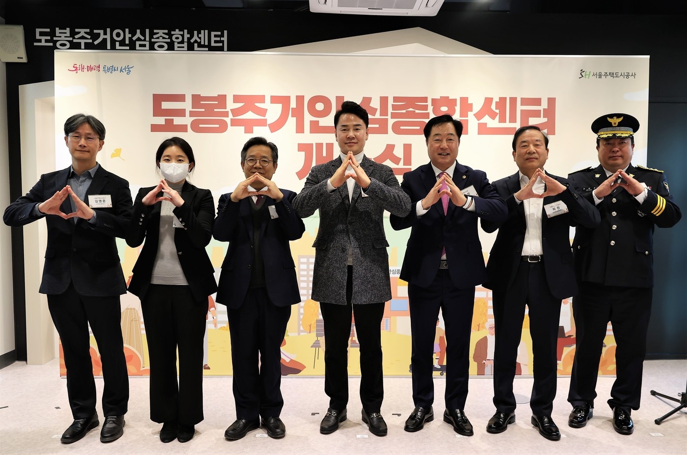 김영준 SH공사 주거복지본부장(왼쪽부터), 이민경 서울시 주택정책실 주거안심지원반장, 김헌동 SH공사 사장, 오언석 도봉구청장, 박석 서울시의회 주택공간위원회 위원, 허원 SH공사 동북센터운영처장, 정병환 도봉경찰서 여성청소년과장 등 개소식 참가자들이 손으로 집을 만들어 보이며, 도봉구민을 위해 원스톱 주거복지 서비스를 제공하겠다는 다짐을 하고 있다(SH 제공).