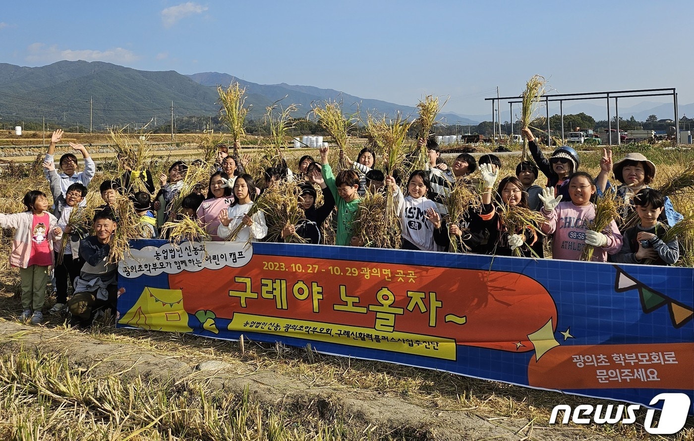  구례 광의초등학교(교장 노형도)- 학생들이 직접 모내기한 벼를 전통방식으로 추수한 뒤 벼를 들고 단체사진을 촬영하고 있다.(전남교육청 제공)/뉴스1 