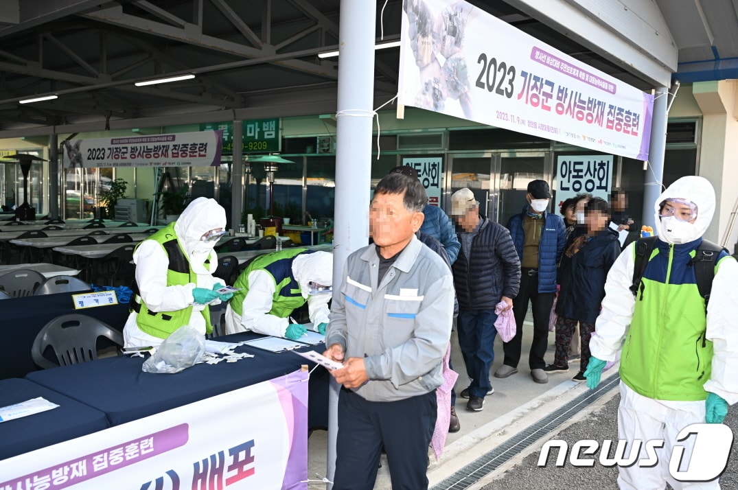 방재요원들이 훈련 참여 주민들에게 방호약품을 배부하고 있다&#40;기장군청 제공&#41;