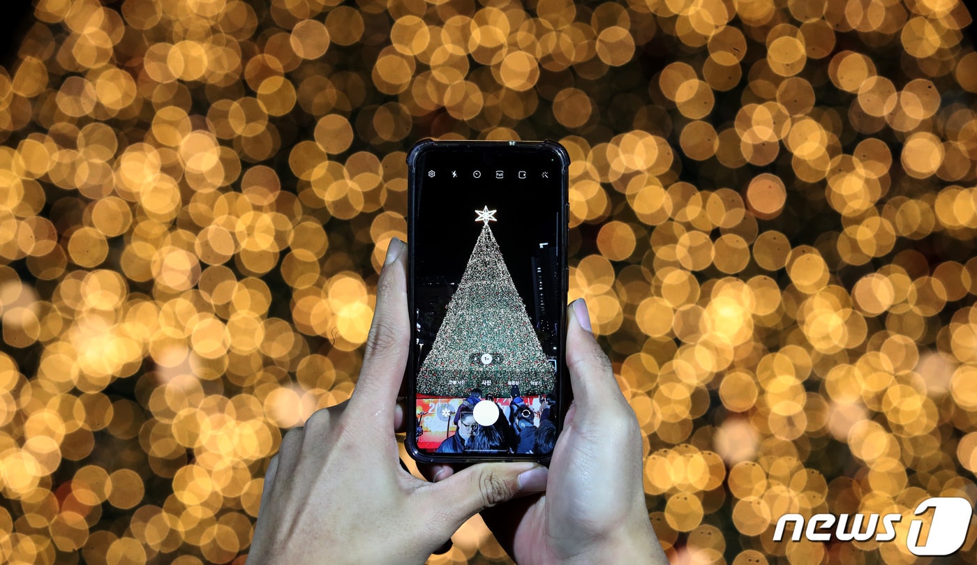 1일 대전 유성구 유성온천공원에 설치된 대형 크리스마스 트리 앞에서 시민들이 크리스마스 분위기를 즐기고 있다. 대전 유성구는 이달 3일까지 유성온천공원 일대에서 ‘유성온천 크리스마스 축제’ 개최한다. 축제는 크리스마스 마켓, 공연, 회전목마 놀이존, 길거리 간식존 등 전 세대가 즐길 수 있는 행사로 꾸며진다. 2023.12.1/뉴스1 ⓒ News1 김기태 기자