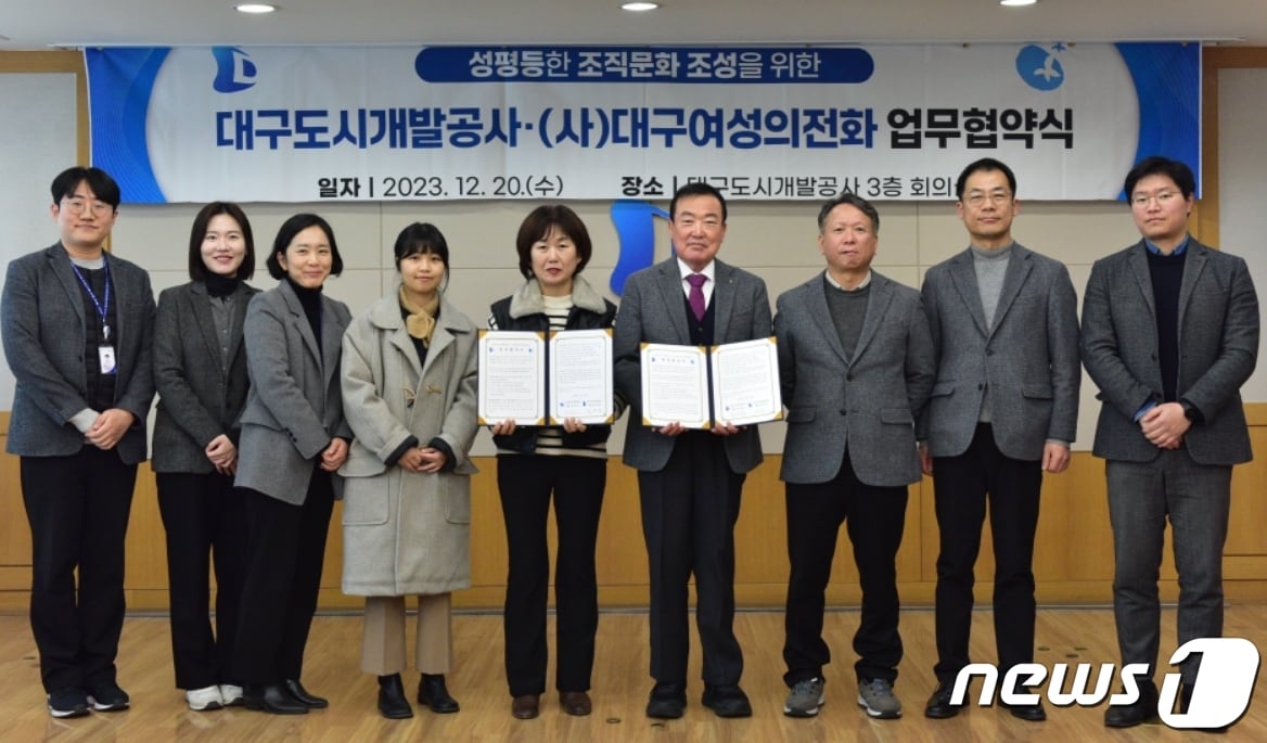 정명섭 대구도시개발공사장(오른쪽 네번째)과 송경인 대구여성의전화 대표(왼쪽 다섯번째)가 '성평등한 조직문화 조성'을 위한 업무협약을 체결한 뒤 협약서를 펼쳐 보이고 있다.(대구도시개발공사 제공)