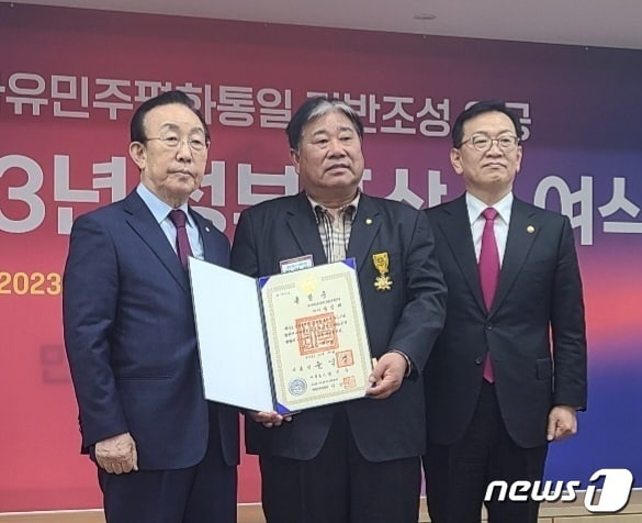 민주평화통일자문회의 양산시협의회 박말태 고문(가운데)이 2023년도 정부포상 수여식에서 윤석열 대통령으로부터 국민훈장 목련장을 수훈하는 영예를 안았다. (양산시 제공)