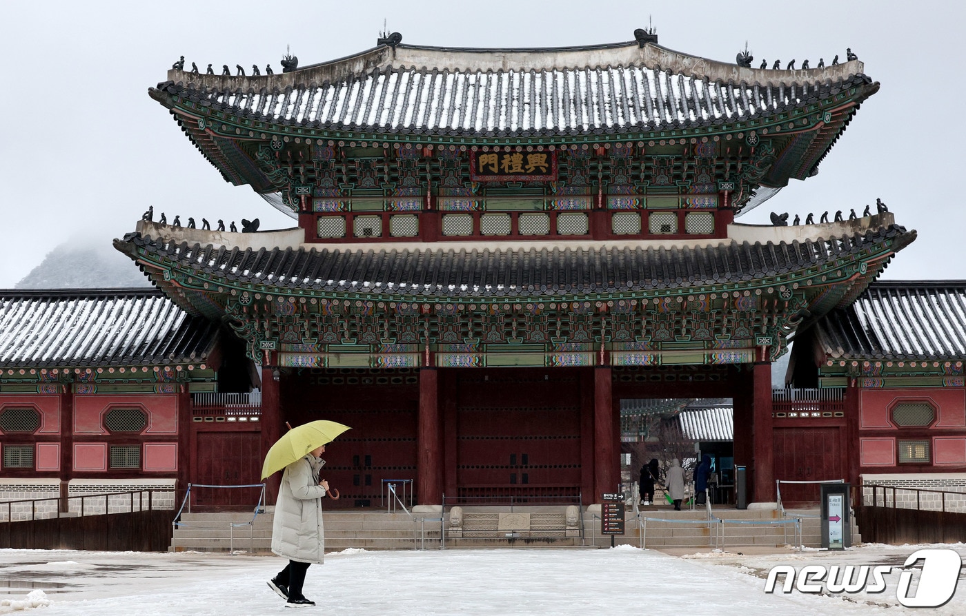 아침까지 약한 눈비가 이어진 31일 오전 서울 종로구 경복궁을 찾은 관광객이 설경을 바라보고 있다. 기상청은 오늘 오전 비가 그친 뒤 흐린 날씨가 이어져 해넘이를 보기 어렵고 새해 해맞이는 볼 수 있을 것이라고 예보했다. 2023.12.31/뉴스1 ⓒ News1 장수영 기자