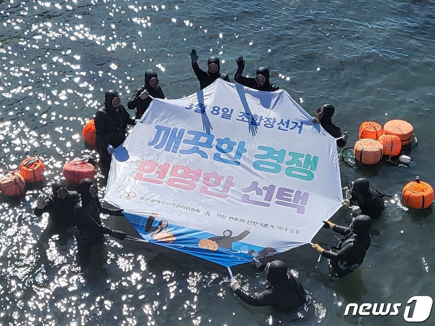 22일 오전 부산 기장군 연화리 바다에서  신암어촌계 해녀들이 '청정바다 클린선거' 퍼포먼스를 펼치고 있는 모습(부산시선거관리위원회 제공).