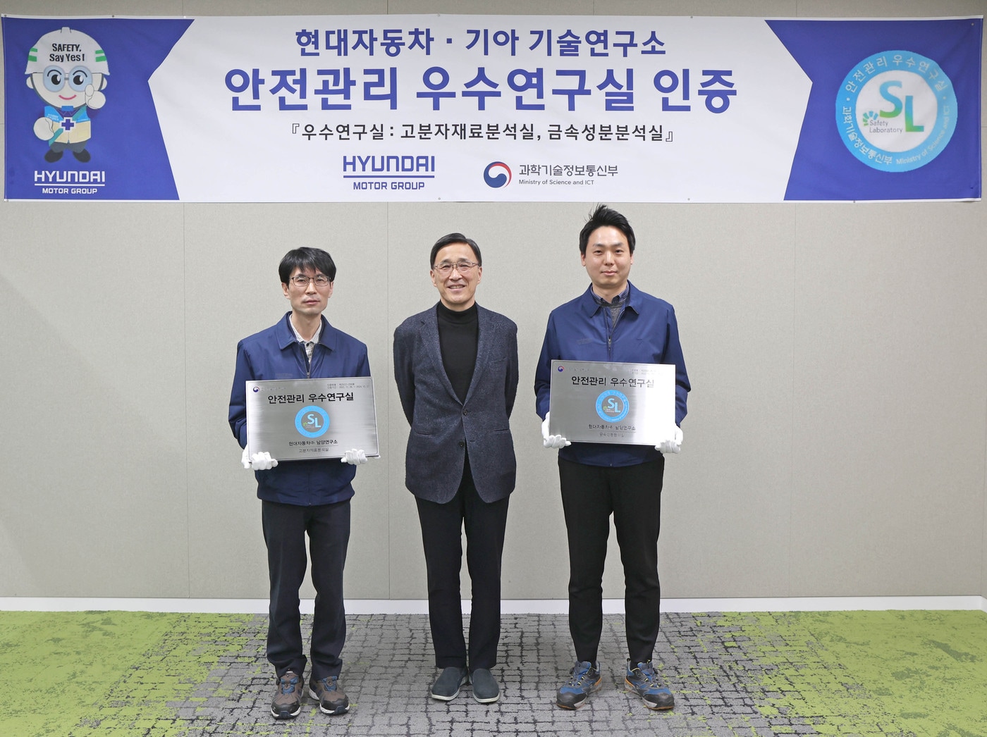 박정국 현대차·기아 연구개발본부 사장(가운데)과 연구원들이 과학기술정보통신부 주관 '안전관리 우수연구실 인증' 현판을 들고 포즈를 취하는 모습.(현대차·기아 제공)