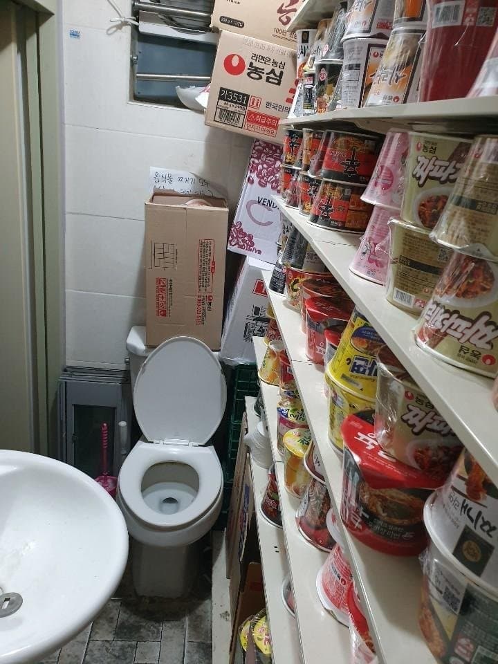 한 편의점이 라면 재고를 화장실에 쌓아둔 사진이 공개되며 논란을 불렀다. (디시인사이드 편의점 갤러리)