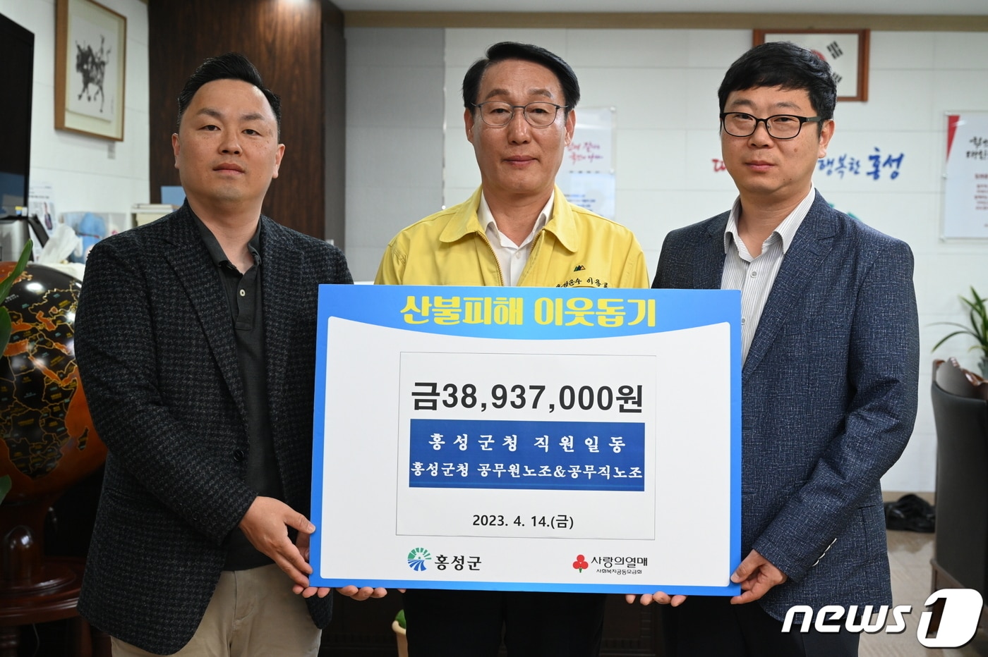 14일 이용록 홍성군수(가운데)와 직원들이 모은 성금 3900여 만원을 충남사회복지공동모금회에 전달한 뒤 기념촬영을 하고 있다. (홍성군 제공) /뉴스1