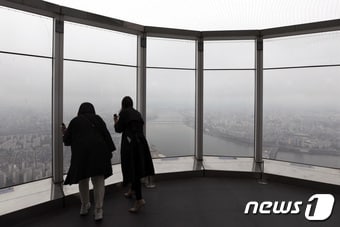 절기상 곡우(穀雨)인 20일 오후 서울 송파구 롯데월드타워 전망대 '서울스카이'를 찾은 시민들이 구름 낀 한강 일대를 보고 있다. 2023.4.20/뉴스1 ⓒ News1 구윤성 기자