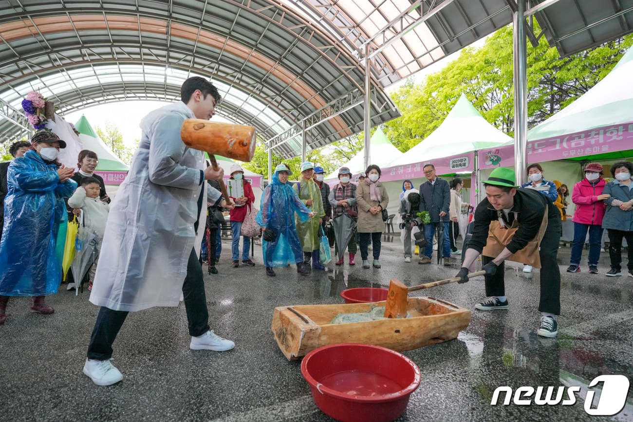 연휴 이틀째인 6일 강원 양구군 서천 레포츠공원 일원에서 열리는 곰취축제장에 한 관광객이 우비를 입고 곰취 떡메치기 체험을 하고 있다.(뉴스1 DB)