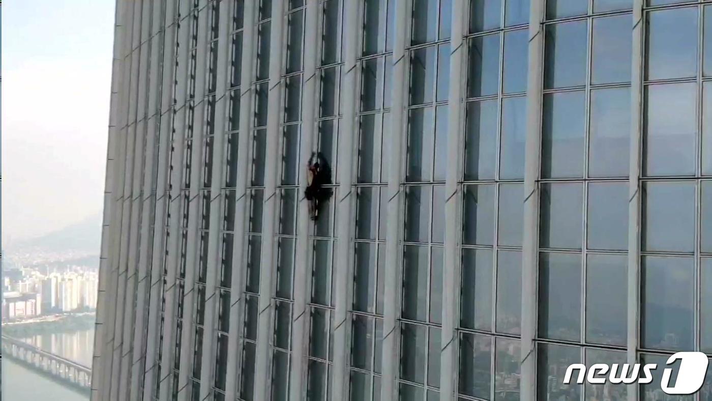 영국인 조지 킹 톰슨이 6월 12일 서울 송파구 잠실 롯데월드타워를 맨손으로 등반하고 있다. (송파소방서 제공) 2023.6.12/뉴스1