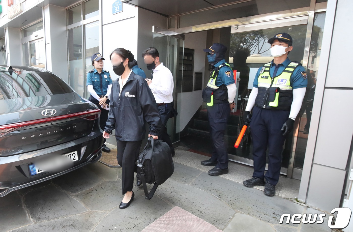 국가정보원과 경찰 관계자들이 14일 오전 제주 연동 전국학교비정규직노동조합 제주지부에 대해 국가보안법 위반 혐의로 압수수색을 마친 뒤 압수품을 들고 나오고 있다. 2023.6.14/뉴스1 ⓒ News1 오현지 기자