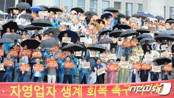 한국외식업중앙회 소속 회원들이 20일 서울 여의도 국회 본청 앞에서 열린 자영업자·소상공인 생계 회복 촉구 기자회견에서 최저임금 인상 반대 등 구호를 외치고 있다. 뉴스1 DB