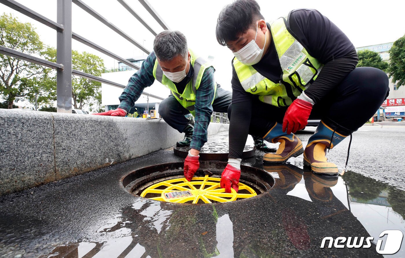 광주 북구 건설과 하수방재팀 직원들이 장마철 집중호우에 대비 설치한 맨홀 추락방지 안전망 점검을 하고 있다. (광주 북구 제공) ⓒ News1 이수민 기자