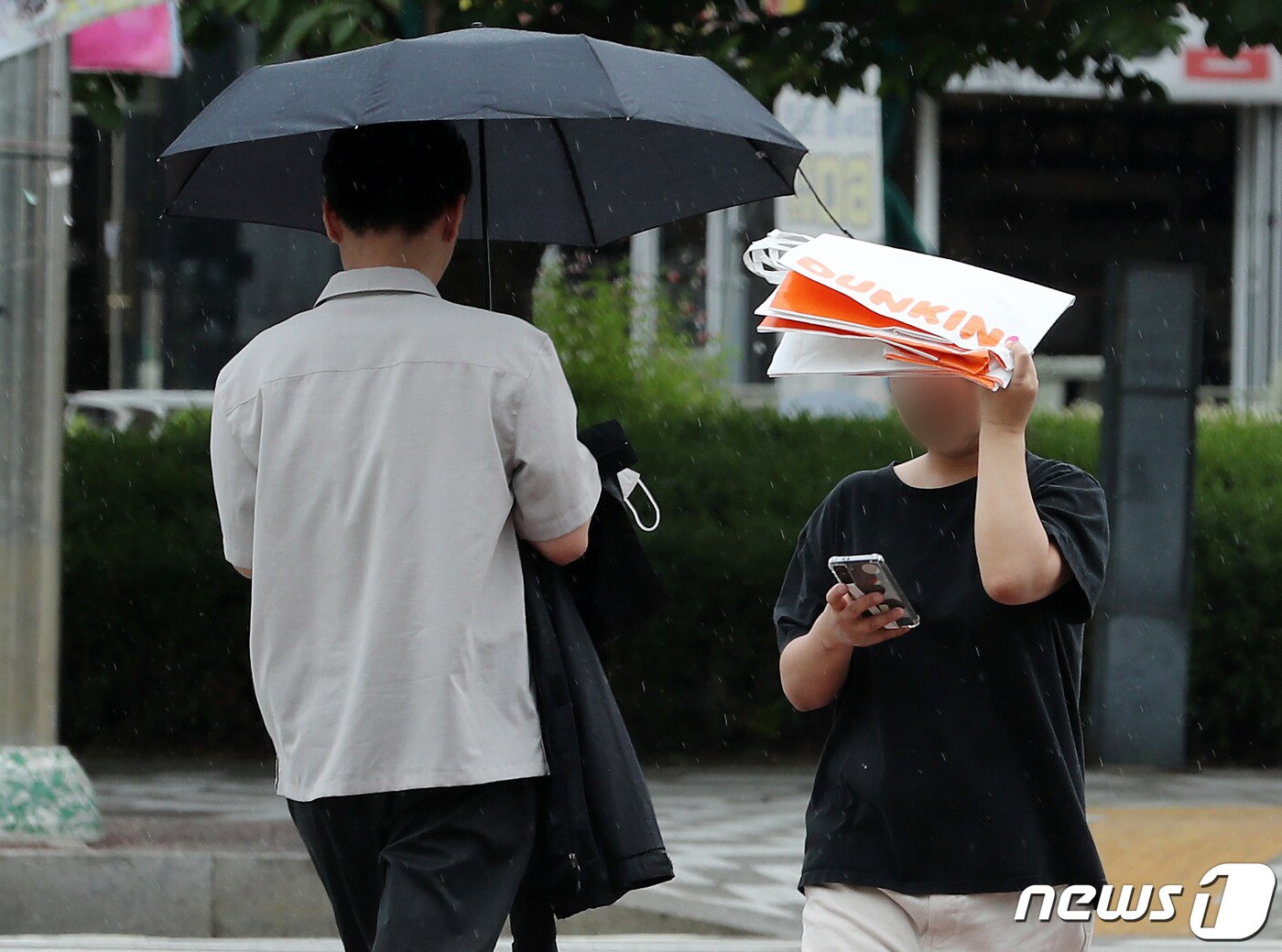 26일 경기 지역은 새벽부터 비가 내리는 가운데 시간당 30㎜ 내외의 강한 비가 올 것으로 예상된다. 사진은 지난 8일 고양시 킨텍스 인근에서 한 시민이 종이가방으로 비를 막고 있는 모습. 2023.6.8/뉴스1 ⓒ News1 이동해 기자