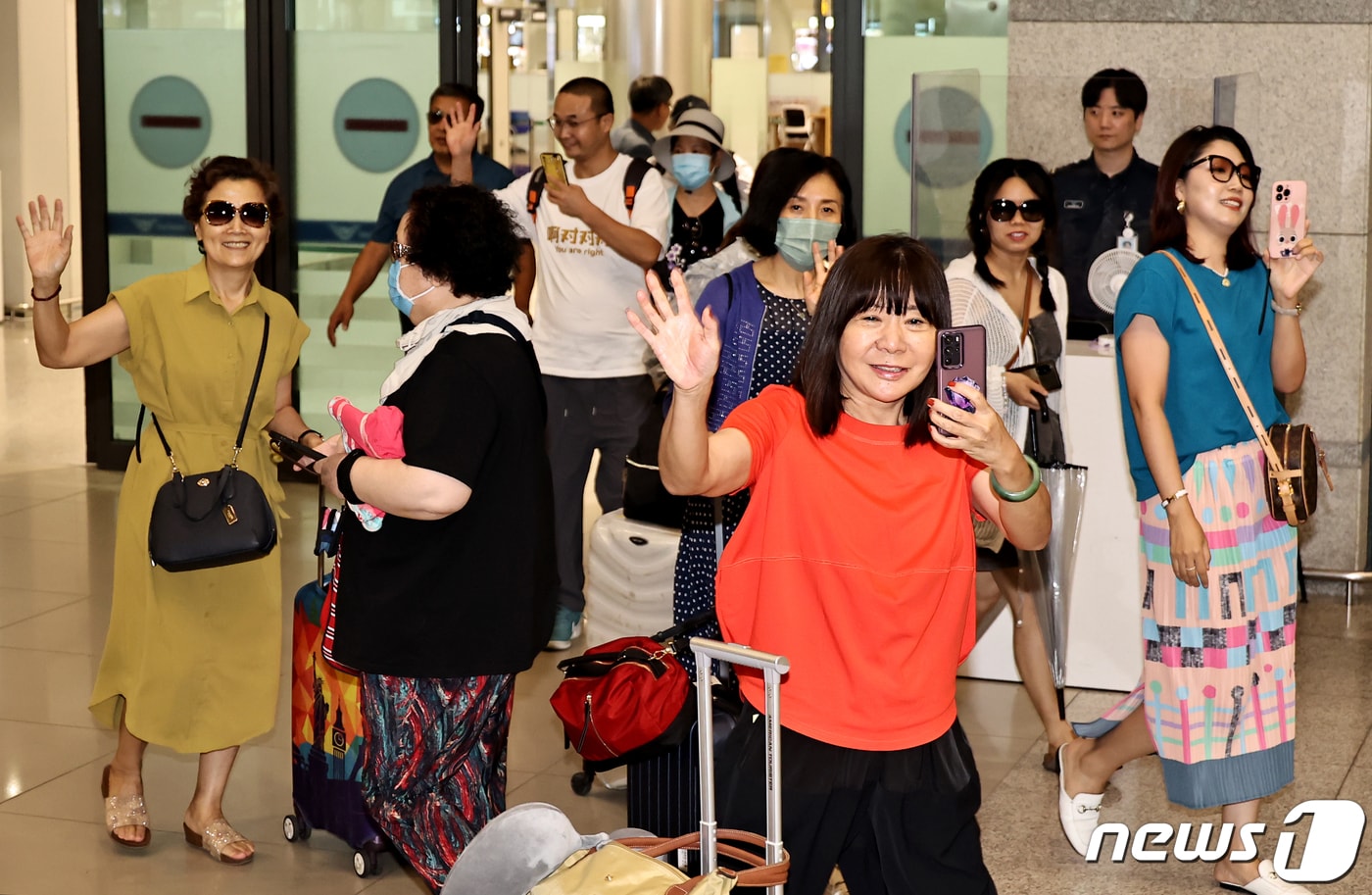 중국인 단체 관광객들이 24일 오후 인천국제공항을 통해 입국하며 손을 흔들어 인사하고 있다. 한국관광공사는 중국 방한 관광시장 정상화에 따른 중국 방한단체 맞이 환대 행사를 열고 이날 입국한 관광객들에게 꽃다발과 기념품을 전달했다. (공동취재) 2023.8.24/뉴스1 ⓒ News1 박정호 기자
