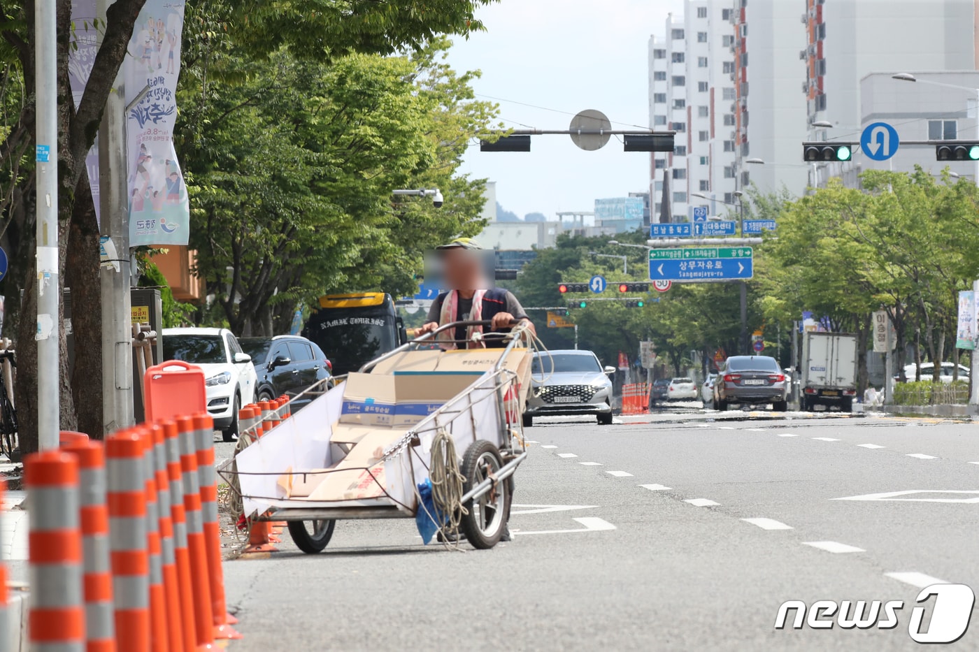 35도를 웃도는 찜통더위가 계속되는 가운데 광주 서구 한 도로에서 폐지줍는 한 어르신이 손수레를 끌고 도로를 지나가고 있다.2023.8.3/뉴스1 ⓒ News1 김태성 기자