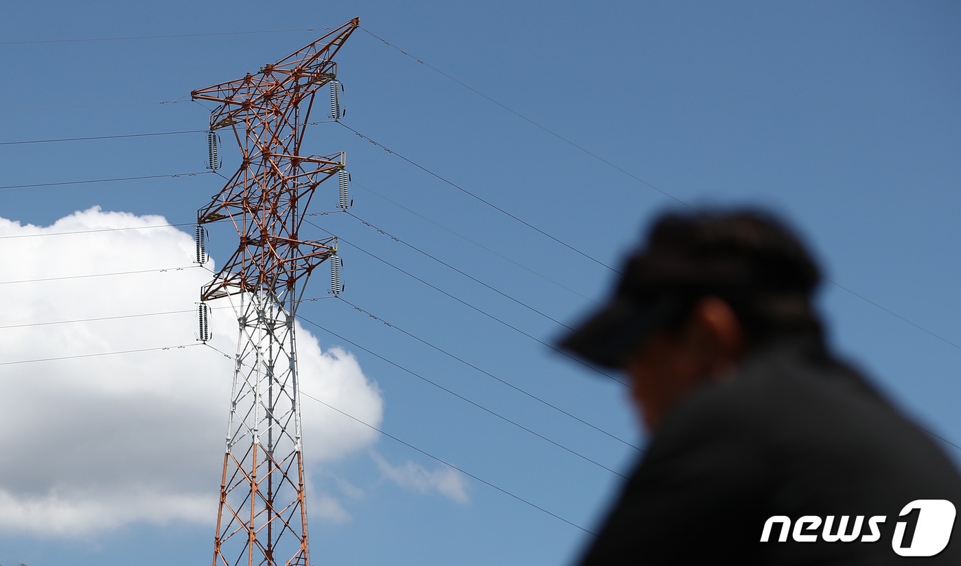 올여름 전력수요가 최대치를 기록할 것으로 전망된 8일 서울 영등포구 선유도공원에서 자전거를 타는 시민 뒤로 송전탑이 보이고 있다. 2023.8.8/뉴스1 ⓒ News1 김민지 기자