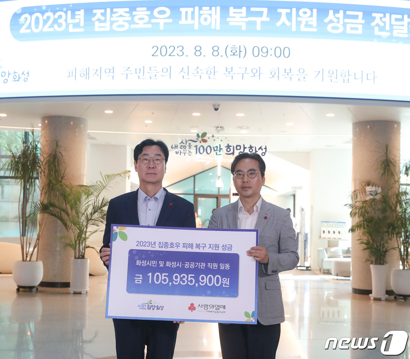 정명근 화성시장(사진 왼쪽)이 집중호우 피해지역 복구 지원 성금을 전달한 뒤 기념촬영을 하고 있다. (화성시 제공)