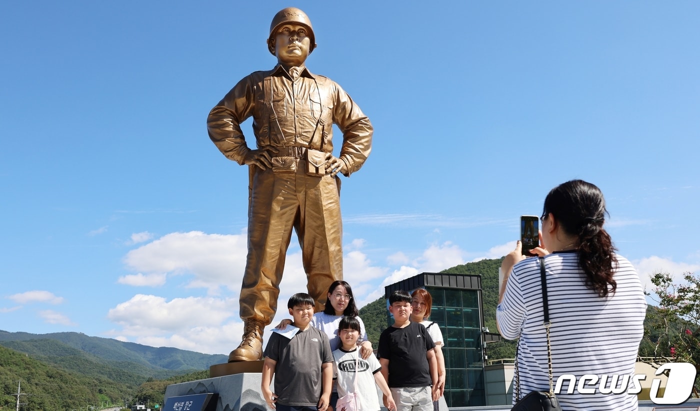 다부동전적기념관을 찾은 가족 단위 관람객이 12일 백선엽 장군 동상을 배경으로 기념촬영을 하고 있다.(칠곡군 제공) 2023.9.13/뉴스1