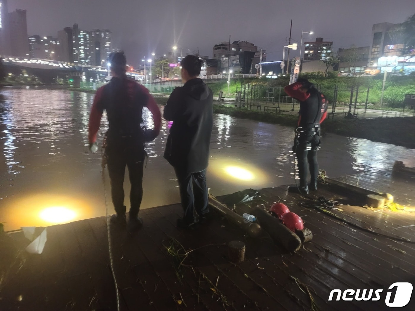 소방이 20일 오후 갑작스러운 많은 비로 불어난 물에 휩쓸려간 여성을 찾기 위해 수색작업을 벌이고 있다. &#40;부산소방재난본부 제공&#41;