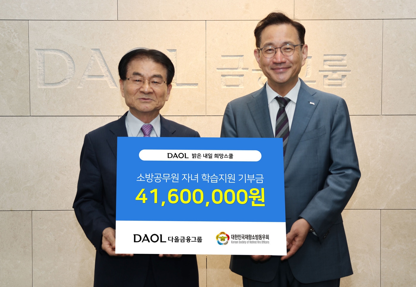 김철종 대한민국재향소방동우회 상임고문(왼쪽)과 김태우 다올금융그룹 ESG위원장이 지난 25일 소방공무원 자녀를 위한 기부금을 전달하고 기념촬영을 하고 있다.(다올금융그룹 제공)