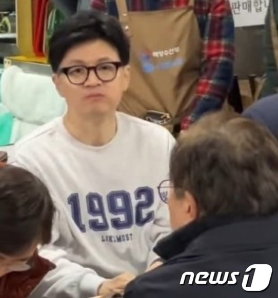 2024년 1월 11일 한동훈 국민의힘 비대위원장이 롯데 자이언츠가 마지막으로 한국시리즈에서 우승한 1992년이 적힌 옷을 입고 부산 중구 남포동 자갈치시장에서 저녁 식사를 하고 있는 모습. (온라인커뮤니티 갈무리) 2024.01.11 ⓒ 뉴스1