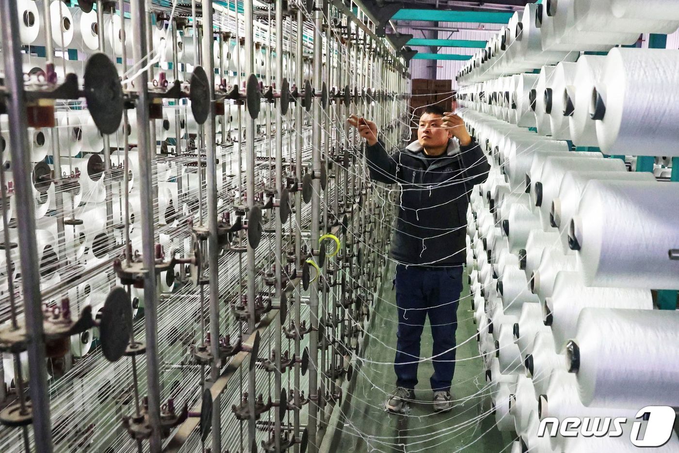 중국 동부 장수성 롄윈강 소재 카페트 공장에서 직원이 일하고 있다. 2024.1.17ⓒ AFP=뉴스1