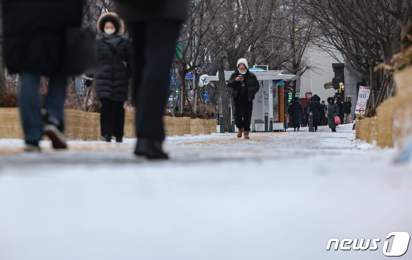 서울 등 수도권 지역에 한파주의보 내려진 22일 오전 서울 종로구 광화문 네거리에서 시민들이 밤 사이 내린 눈 위를 지나가고 있다. 2024.1.22/뉴스1 ⓒ News1 김도우 기자