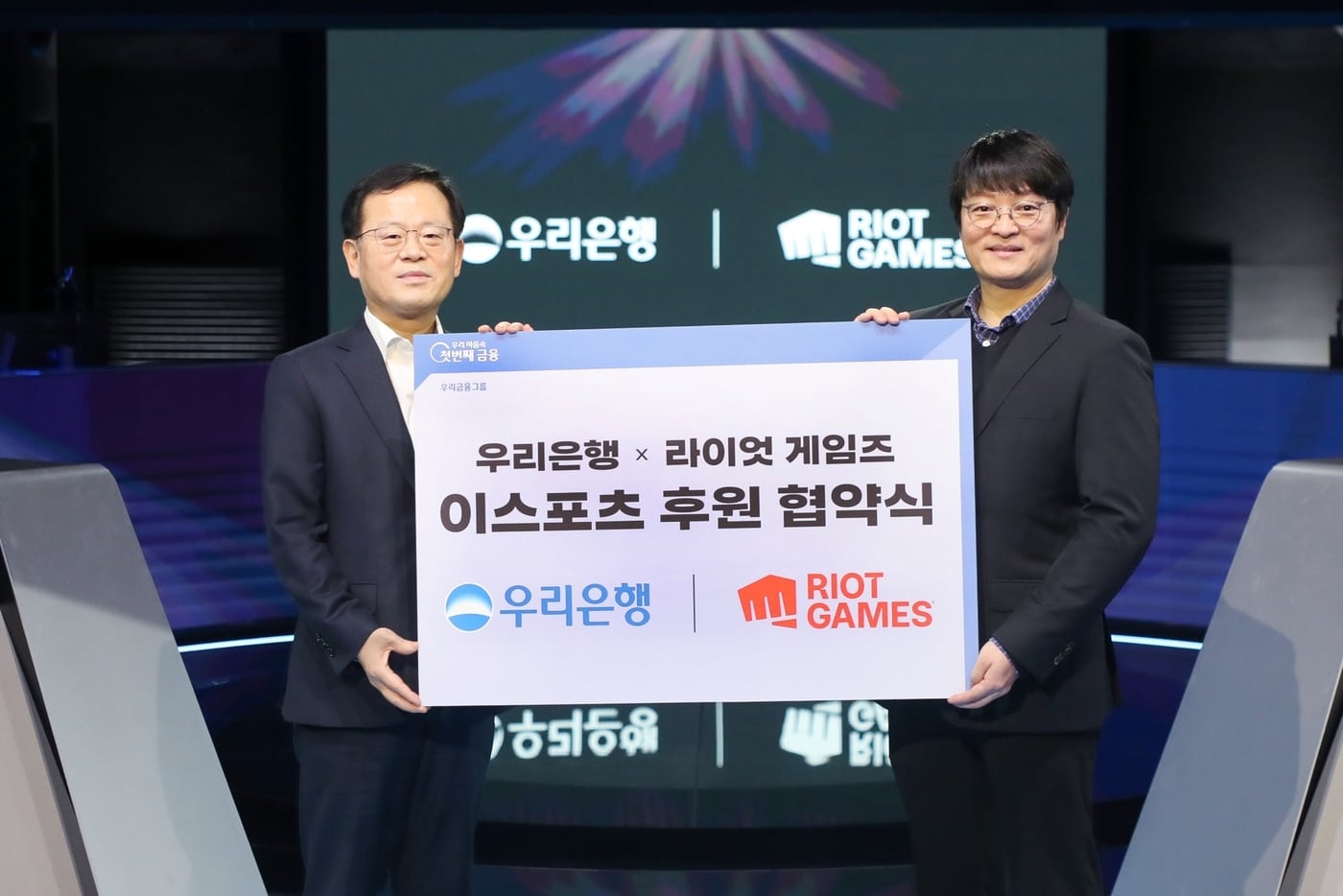 지난 30일 종로구 롤파크 이스포츠 경기장에서 진행된 이스포츠 후원 협약식에서 조병규 우리은행장(왼쪽)과 조혁진 라이엇 게임즈 코리아 대표가 기념사진을 촬영하고 있다.(우리은행 제공)