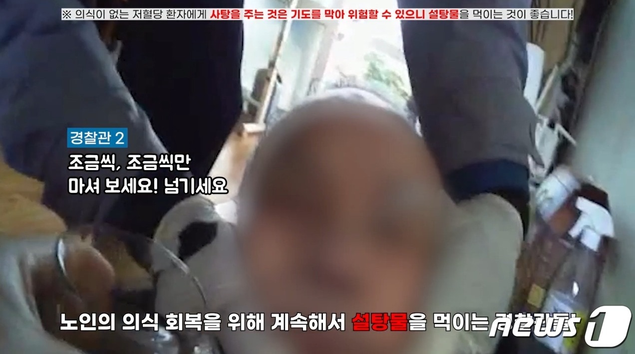 경찰이 저혈당 쇼크로 의식을 잃고 쓰러진 70대 노인에게 설탕물을 먹이고 있다. (대전경찰청 유튜브 캡처) /뉴스1 