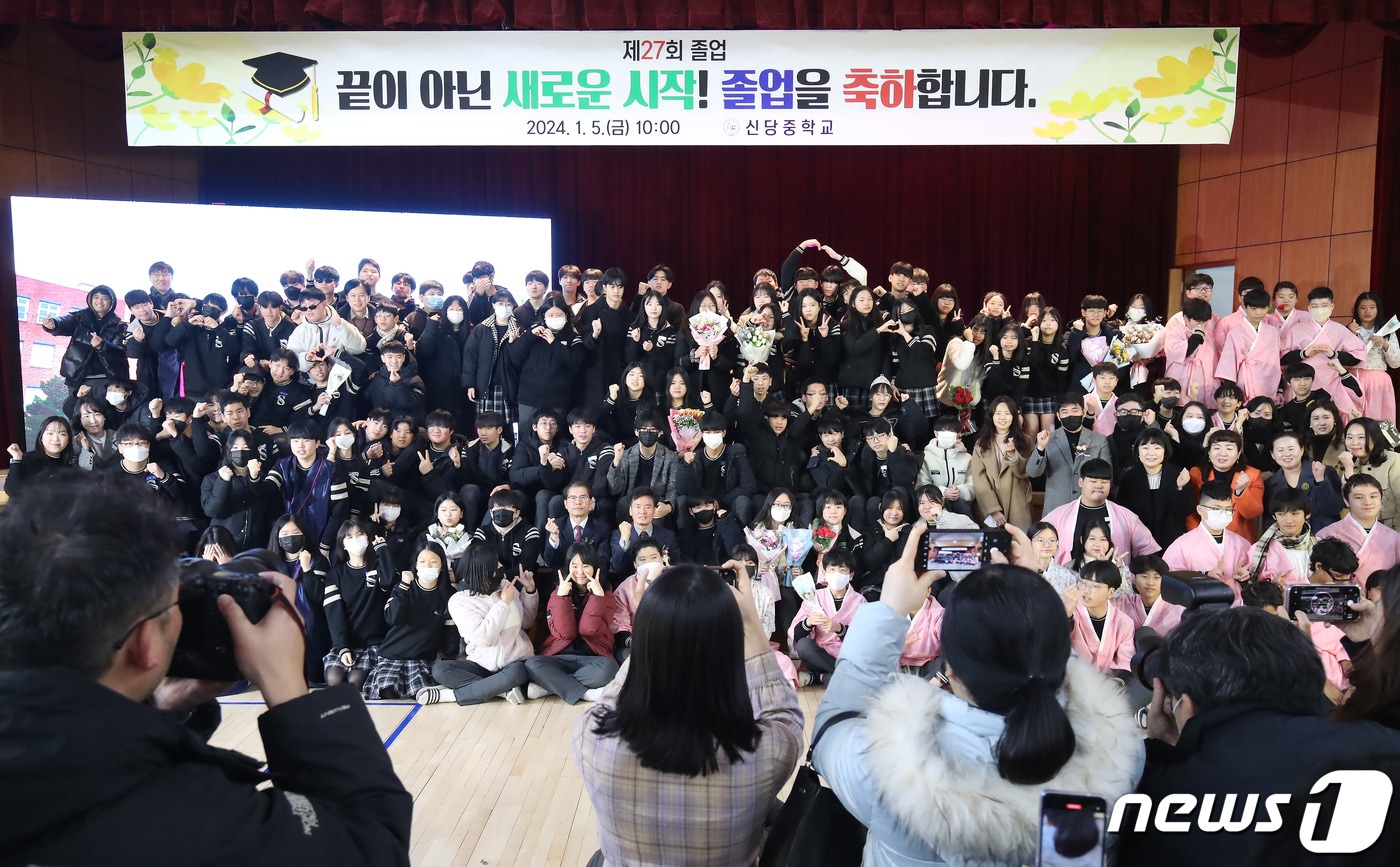 지난 5일 대구 달서구 신당중학교 강당에서 제27회 마지막 졸업식을 마친 졸업생과 재학생들이 기념촬영을 하고 있다. 1995년 개교한 신당중학교는 계속되는 학생 수 감소에 따라 이날 마지막 졸업생 61명(총 7693명)을 배출한 뒤 2024년 3월1일자로 인근 학교와 통폐합된다. 2024.1.5/뉴스1 ⓒ News1 공정식 기자