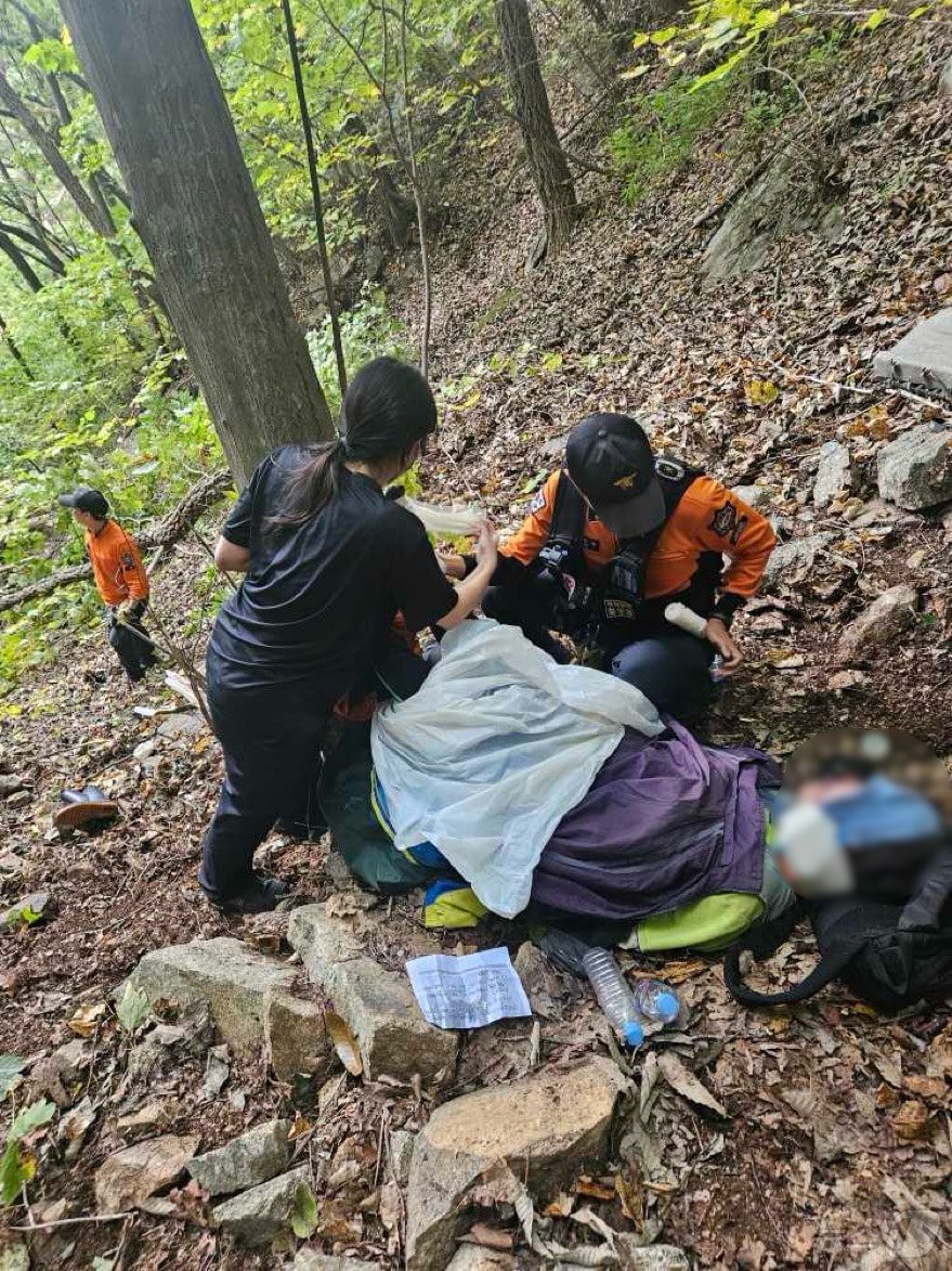 임산물 채취 하러 왔다가 넘어져 다친 60대 여성 치료하는 인제소방서 구조대원들.&#40;인제소방서 제공&#41;