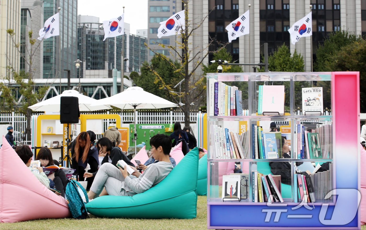 13일 오후 휴일을 맞아 서울 종로구 광화문광장 '서울야외도서관 광화문책마당'을 찾은 시민들이 빈백 소파에 기대어 독서 삼매경에 빠져 있다. 2024.10.13/뉴스1 ⓒ News1 오대일 기자