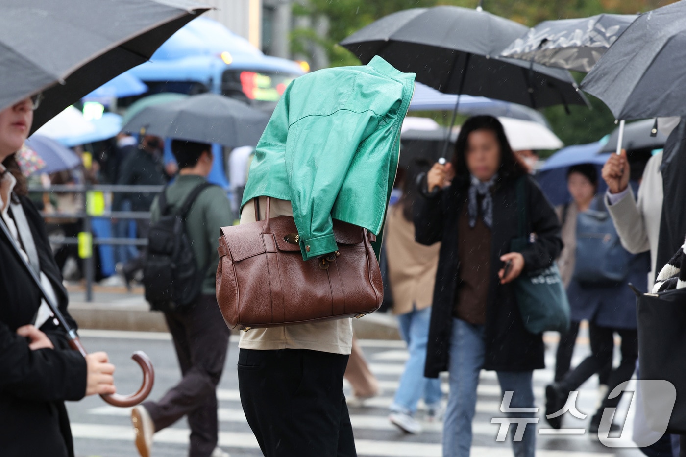 전국적으로 가을비가 내린 22일 서울 광화문네거리에서 우산을 챙기지 못한 시민이 겉옷으로 비를 가리고 있다. 기상청은 이날 종일 가을비가 내리면서 선선함이 감돌다가 오는 24일에는 서울 아침 최저 기온이 8도까지 떨어질 것으로 예보했다. 2024.10.22/뉴스1 ⓒ News1 신웅수 기자