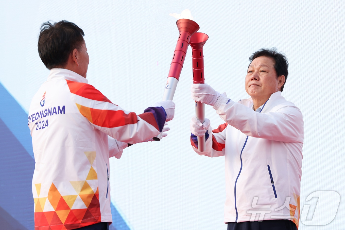 박완수 경남지사&#40;오른쪽&#41;가 4일 도청 광장에서 열린 성화합화식에서 통영 제승당에서 채화한 성화를 인계받고 있다.&#40;경남도 제공&#41;